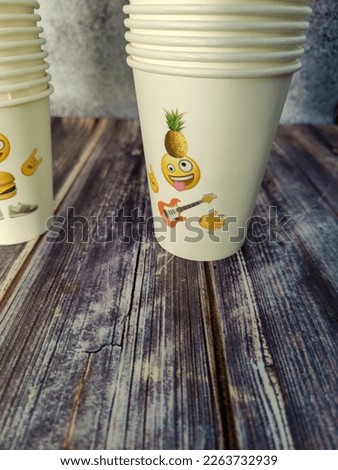 Some stack's of paper disposable cups for drinks with a picture of a person. Close-up