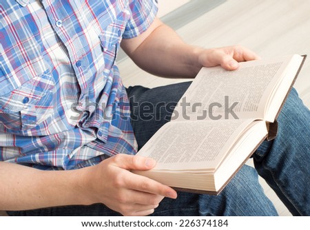 Man reading a book while sitting on the floor