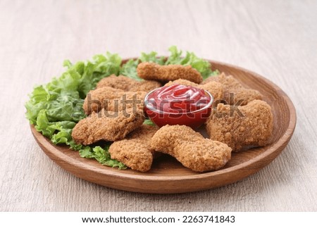 chicken nuggets served with tomato sauce and lettuce leaf garnish Royalty-Free Stock Photo #2263741843