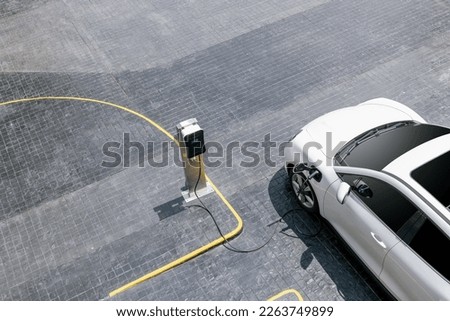 Aerial top view image of progressive green energy-powered charging station, electric vehicle at public car park with EV car concept for alternative transportation and energy infrastructure. Royalty-Free Stock Photo #2263749899