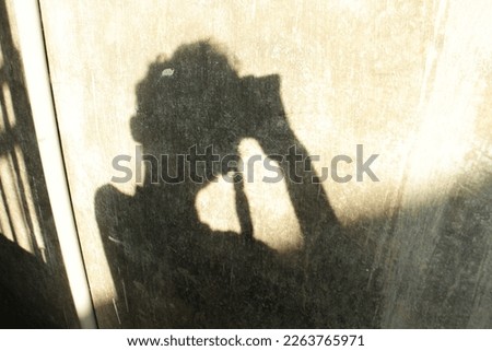 A shadow of a person taking a photo