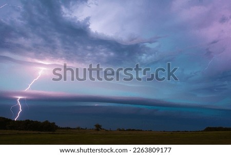 This electrifying stock photo captures the raw power and beauty of a lightning bolt striking through a shelf cloud, a breathtaking natural phenomenon.