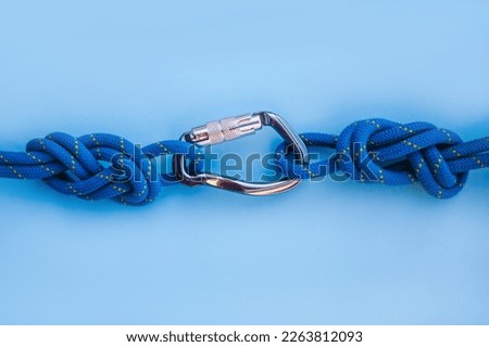 Grey carbine with clutch. Equipment for climbing and mountaineering. Safety rope. Knot eight Royalty-Free Stock Photo #2263812093