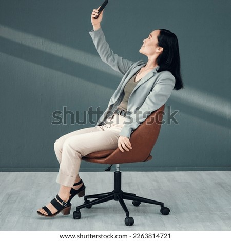 Selfie, video call and woman with a phone for connection, internet and communication at work on a chair. Corporate and Asian employee reading an email, message or chat on a mobile app in an office