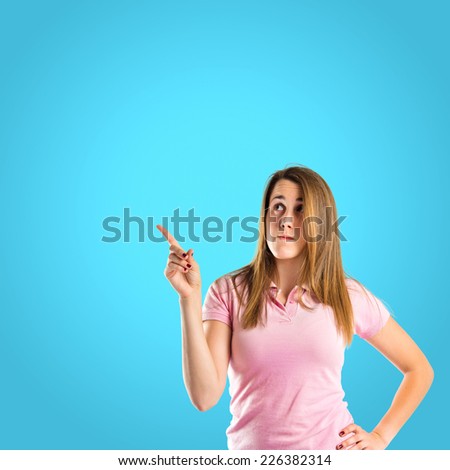 Young girl thinking over blue background