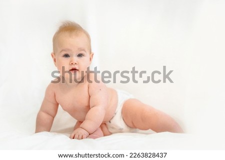 Beautiful Little Caucasian baby in a diaper on a white background