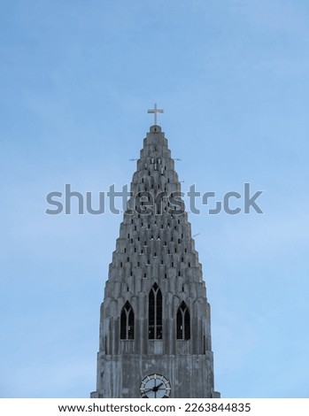 Detail of the upper part of the Hallgrimskirkja church where you can see the details of the antennas, the cross and tourists taking photos of Reykjavik from its viewpoint