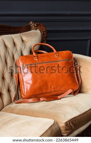 close-up photo of orange leather bag corporate.