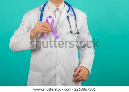 Male doctor holding a purple ribbon in her hands ADD,ADHD,Alzheimer Disease ,Arnold Chiari Malformation,Childhood Hemiplegia stroke, Epilepsy, Chronic Acute Pain,Crohns Royalty-Free Stock Photo #2263867301