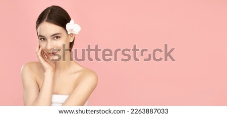 Beautiful young woman with clean skin on isolated pink background.