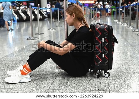 Sad (tired) woman sitting in the airport - missed or cancelled flight concept. Royalty-Free Stock Photo #2263924229