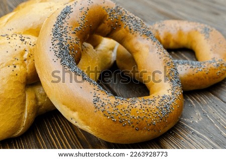 Bagel and bread sprinkled with poppy seeds on a wooden background