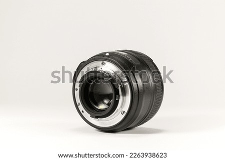 Macro photo of a black 50mm 1.8 back of the lens on a white background with a closed aperture for a photo or video camera
