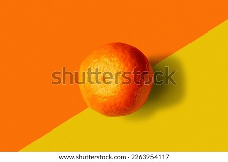 Mandarin close-up on yellow-orange background, top view