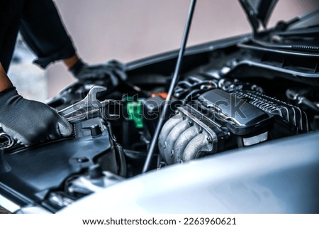 Car care maintenance and servicing, Close-up hand technician auto mechanic using the wrench to repairing change spare part car engine problem and car insurance service support. Royalty-Free Stock Photo #2263960621
