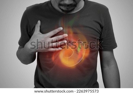 A man burning sensation in the of the middle chest because of acid reflux. Hot in middle chest caused by hyperacidity. Royalty-Free Stock Photo #2263975573