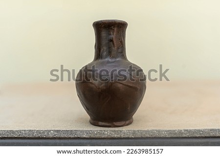 Brown ceramic jug on a gray background. For storage of water, milk.