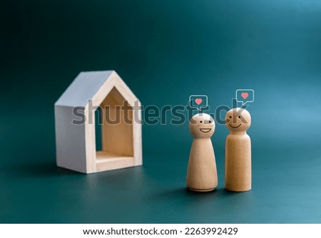 Happy smiling of couple lover wooden figure with heart symbols floating overhead, standing front of miniature minimal white wood house. Building family. Property, real estate investment concept. Royalty-Free Stock Photo #2263992429