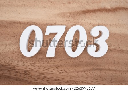 White number 0703 on a brown and light brown wooden background.
