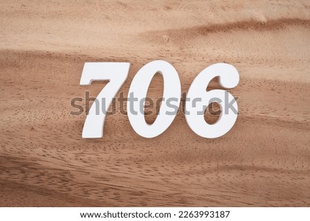 White number 706 on a brown and light brown wooden background.