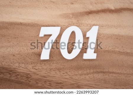 White number 701 on a brown and light brown wooden background.