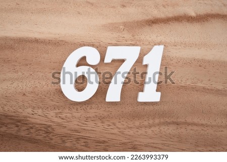White number 671 on a brown and light brown wooden background.