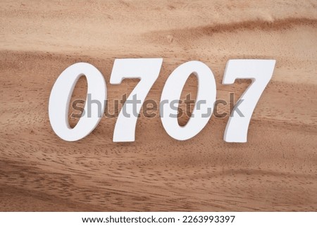 White number 0707 on a brown and light brown wooden background.