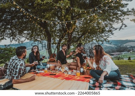 Group of young happy friends having pic-nic outdoors - People having fun and celebrating while grilling ata barbacue party in a countryside Royalty-Free Stock Photo #2264005865