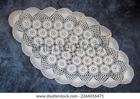 Handcrafted lace tablecloth, coffee table cover. Warm white or beige vintage knit lace. Crochet lace handcrafted lace texture. abstract for background. top view. Royalty-Free Stock Photo #2264016471