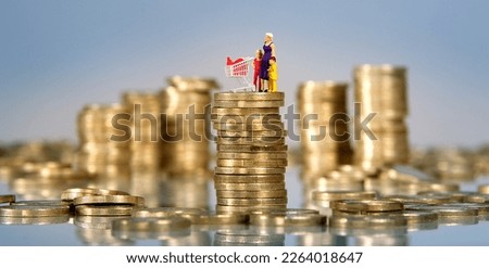 Euro coins and miniature people, mother with children and shopping cart on pile of coins, inflation, supermarket goods and food price increase Royalty-Free Stock Photo #2264018647