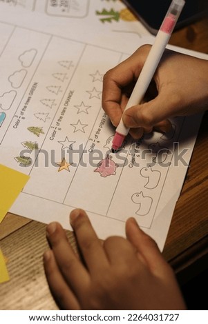 a photo of someone's hand holding a pencil to color a picture