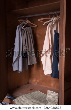 Abandoned messy bedroom with old used clothing on the ground and on the wardrobes. Royalty-Free Stock Photo #2264036873