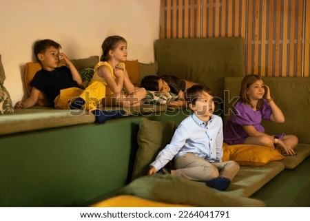 Little boys and girls look shocked and surprised watching movie in home cinema, emotion expression shock unexpected action, activity, entertainment. Kids leisure, hobby, lifestyle concept
