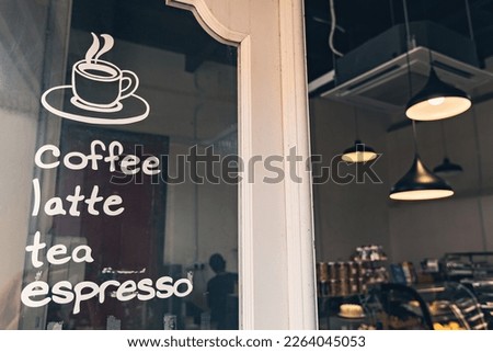 Cozy coffe shop entrance door with coffee menu written on the glass