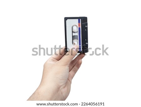 Hand holding old cassette tape isolated on white background. Vintage audio cassette tape on white background Royalty-Free Stock Photo #2264056191