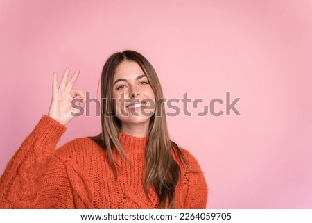 Smiling woman showing OK gesture