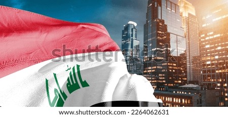 Iraq national flag cloth fabric waving on beautiful blue sky.