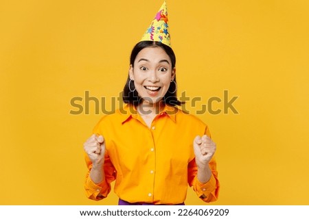 Happy fun young overjoyed excited woman wears casual clothes hat celebrate do winner gesture celebrate clenching fists say yes isolated on plain yellow background. Birthday 8 14 holiday party concept Royalty-Free Stock Photo #2264069209
