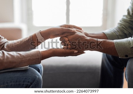 Unrecognizable black woman therapist holding man patient hands against window, giving psychological support while therapy session, cropped indoors shot, closeup, copy space Royalty-Free Stock Photo #2264073997