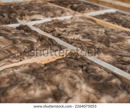 selective focus, mineral wool floor insulation, underfloor heating insulation , warm house, environmentally friendly insulation, energy-saving house construction. close-up. Royalty-Free Stock Photo #2264075053