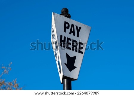 Pay here sign at.a parking site in Ironbridge in Shropshire, UK on a blue sky day
