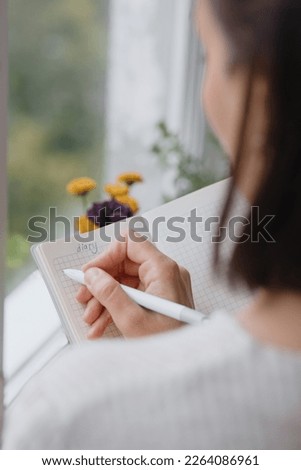 view from back, woman writes notes in notebook or diary. mental health care, psychotherapy and work on control of emotional state. writing by hand in notebook, emotional intelligence. moral support Royalty-Free Stock Photo #2264086961