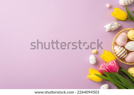 Easter concept. Top view photo of colorful easter eggs in bowl ceramic bunny yellow and pink tulips on isolated lilac background with copyspace