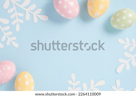 Happy Easter Colorful Easter eggs flat lay on blue background. Stylish tender spring template with space for text. Greeting card or banner