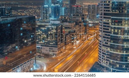 Dubai's business bay office buildings aerial night  with street traffic. Rooftop view of some skyscrapers and new towers under construction