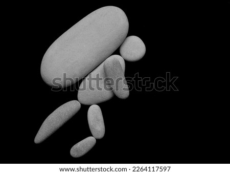 one Hiker man climbing with big heavy backpack on mountain. isolated on black background. male sign, symbol made from many white pebbles, stones. 