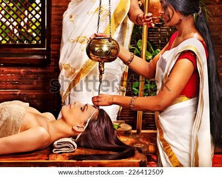Young woman having oil Ayurveda spa treatment. Royalty-Free Stock Photo #226412509