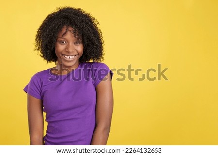 Cool woman with afro hair laughing while looking at camera