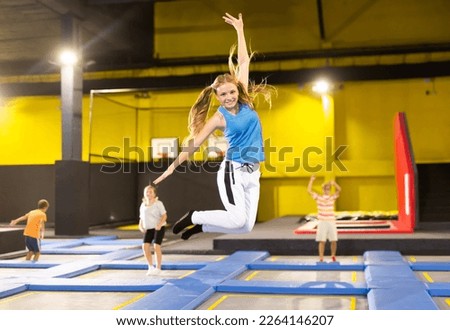 Cheerful active teen girl enjoying jumping on trampoline on indoor inflatable playground.. Royalty-Free Stock Photo #2264146207