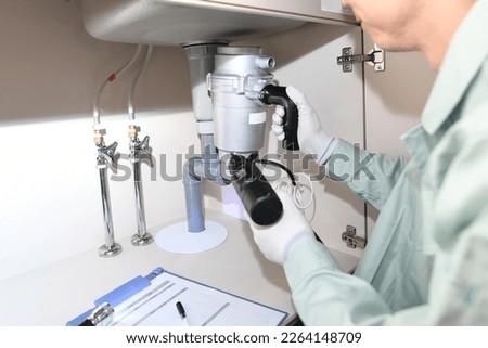 Male worker installing a disposer
 Royalty-Free Stock Photo #2264148709